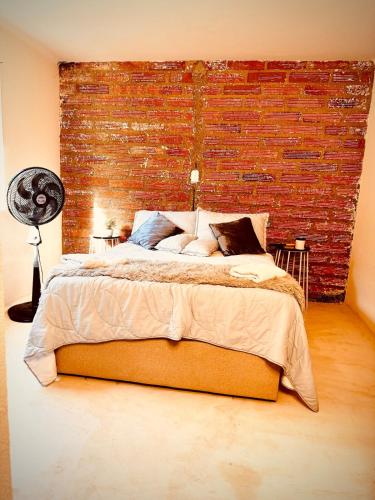 a bedroom with a large bed with a brick wall at The best of Envigado, close to everything in Envigado