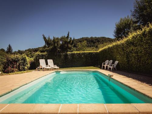 - une piscine avec deux chaises longues et une paire dans l'établissement Cottage in Vézac with Pool & River Nearby, à Vézac