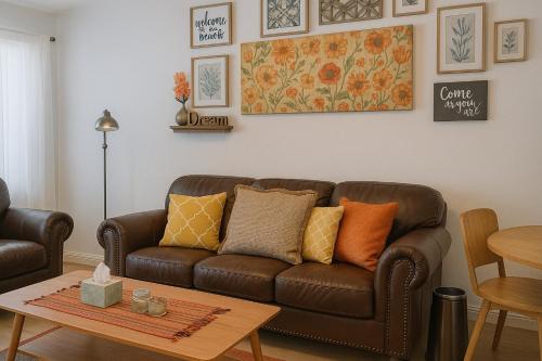 a living room with a brown couch and a table at Charming 2 bdr 1 bath home fenced byard N Pensacola Pet Friendly Close to bases in Pensacola
