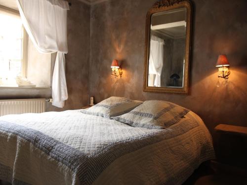 a bedroom with a bed and a mirror on the wall at Magnificent Manor in Vresse-Sur-Semois with Sauna in Vresse-sur-Semois