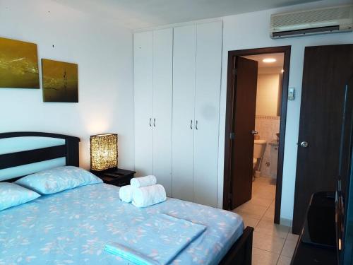 a bedroom with a bed with two towels on it at Departamento con piscina 8 in Salinas