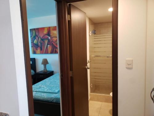 a door to a bedroom with a bed and a painting at Departamento con piscina 8 in Salinas