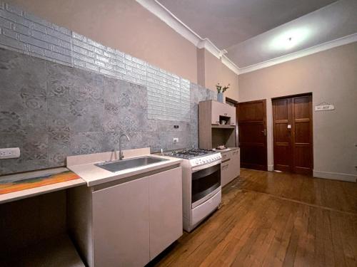 a kitchen with a sink and a stove top oven at CASA AIDA LUZ in Cuenca