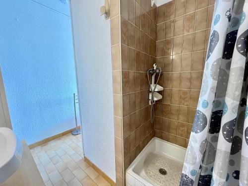 une salle de bain avec une douche avec un rideau de douche dans l'établissement Studio cabine lumineux avec parking privé, face à la plage – Sète - FR-1-338-561, à Sète