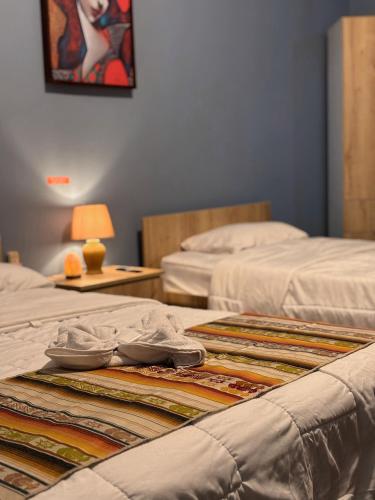 a room with two beds and a table with a blanket at CASA AIDA LUZ in Cuenca