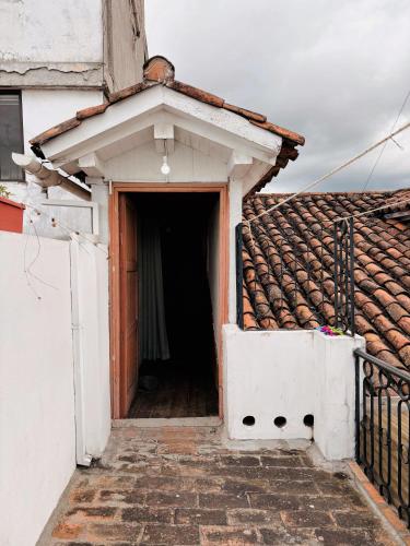 an open door to a house with a tile roof at CASA AIDA LUZ in Cuenca