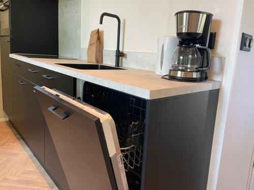 a kitchen with an appliance in an open dishwasher at Chalet in Hengelo near Twickel Castle in Haaksbergen