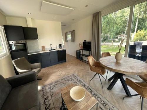 a living room with a table and a kitchen at Chalet in Hengelo near Twickel Castle in Haaksbergen