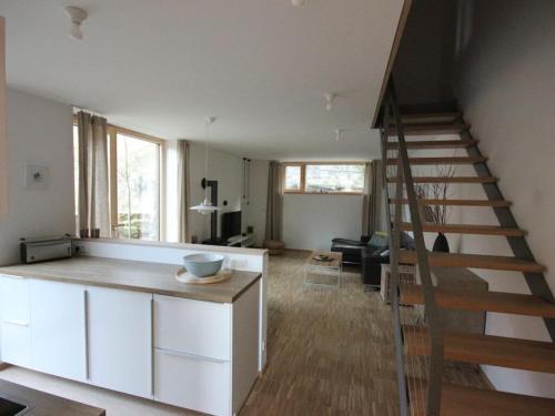 a living room with a staircase leading up to a loft at At the Church Stairs - Holiday Home II in Blankenburg
