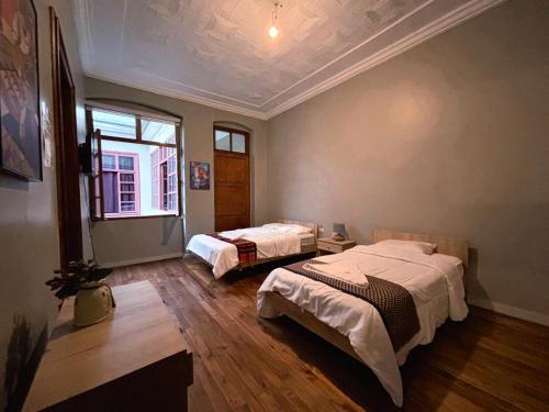 a bedroom with two beds and a window at CASA AIDA LUZ in Cuenca