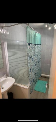 une salle de bain avec un rideau de douche et un lavabo dans l'établissement 30 pas et dans l'eau, à Canet