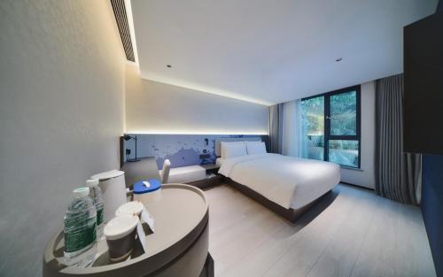 a bedroom with a bed and a desk with a sink at Atour Light Hotel Shenzhen Nanshan Nanyou Clothing City in Shenzhen