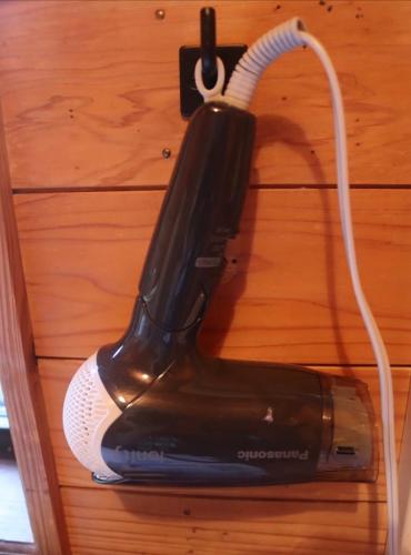 a hair dryer is hanging on a wall at Retreat House in Yakushima