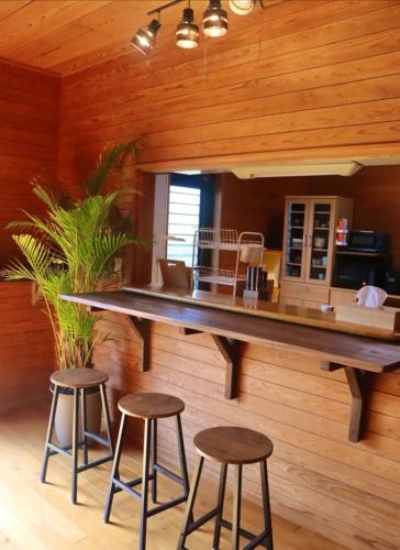 a kitchen with a large counter and stools in a room at Retreat House in Yakushima