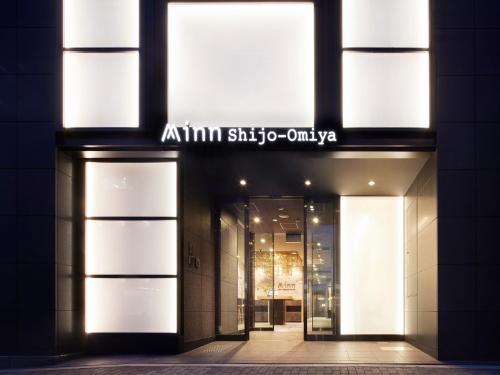 a building with a sign that reads aimim still to exist at Minn Shijo Omiya in Kyoto