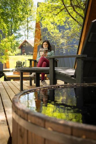 a woman sitting on a bench reading a book at Alto Terralis in Minetué