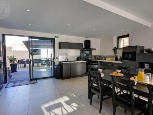 une cuisine avec une table et des chaises et une table dans l'établissement Gîte lumineux avec jardin, jacuzzi, et équipements modernes, idéal pour séjours en famille ou entre amis - FR-1-496-234, à Montchal