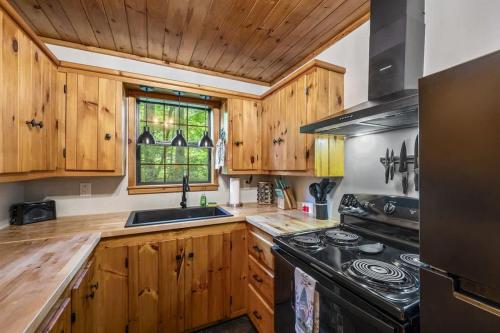 Una cocina con gabinetes de madera y un horno de estufa. en Creekside - 7 Min to Park 20 Min to Gatlinburg, en Cosby