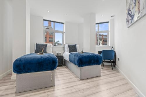 two beds with blue cushions in a bedroom at City Centre Luxury Apartment, Sofa Bed, Netflix, WiFi, Relocators, Contractors, Families Welcome in Leicester