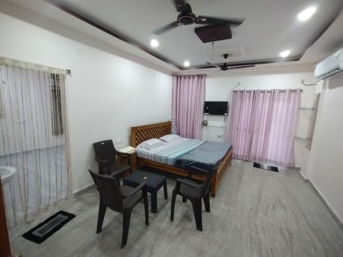 a room with a bed and a table and chairs at KSP Homes in Visakhapatnam