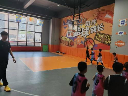a group of children playing basketball in a gym at Central Street Apartment 1 in Harbin