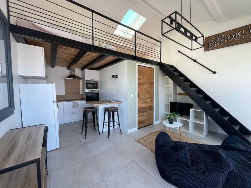 un salon et une cuisine avec un escalier en mezzanine dans l'établissement Cambo-les-Bains : T1 Bis cosy avec jardin et WiFi - FR-1-495-149, à Cambo-les-Bains