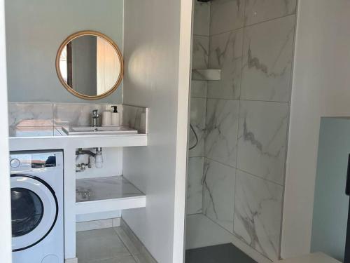 La salle de bains est pourvue d'un lave-linge et d'un miroir. dans l'établissement Cambo-les-Bains : T1 Bis cosy avec jardin et WiFi - FR-1-495-149, à Cambo-les-Bains