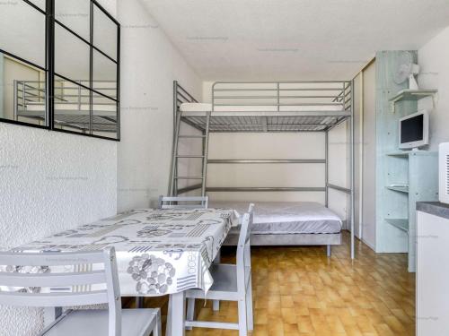 Cette chambre comprend 2 lits superposés, une table et des chaises. dans l'établissement Studio 4 pers, plage à 200m, parking, Narbonne Plage - FR-1-229B-105, à Narbonne