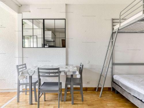 une salle à manger avec une table, des chaises et une échelle dans l'établissement Studio 4 pers, plage à 200m, parking, Narbonne Plage - FR-1-229B-105, à Narbonne
