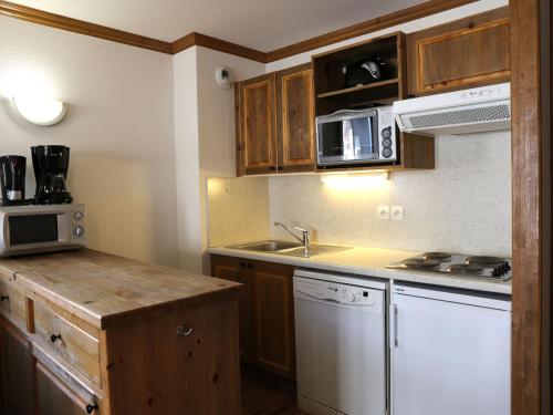 une petite cuisine avec un évier et un micro-ondes dans l'établissement Appartement spacieux 6 personnes avec balcon et WIFI - FR-1-508B-22, à Aussois