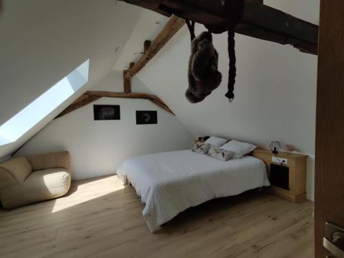 a bedroom with a bed and a couch in a attic at Gîte spacieux et confortable proche de La Flèche - FR-1-410-471 in Villaines-sous-Malicorne