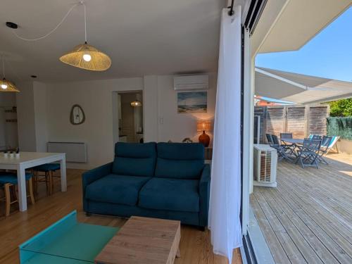 un salon avec un canapé bleu et une table dans l'établissement Appartement chaleureux 6 pers près mer avec parking et wifi - FR-1-239-1114, à Capbreton