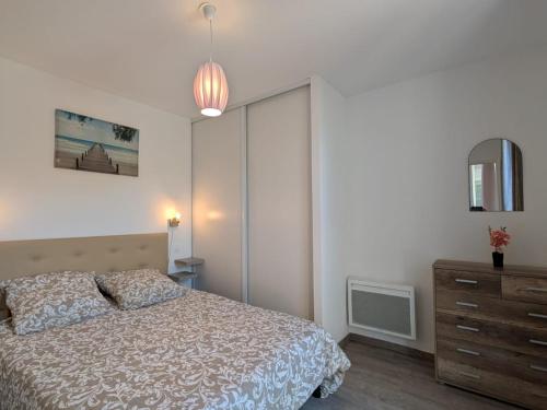 une chambre avec un lit, une commode et un miroir dans l'établissement Appartement chaleureux 6 pers près mer avec parking et wifi - FR-1-239-1114, à Capbreton