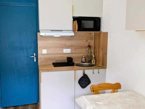 une petite cuisine avec un évier et un micro-ondes dans l'établissement Studio cosy 4 pers à Châtel avec terrasse et parking - FR-1-676-221, à Châtel