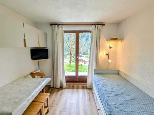 une chambre avec deux lits et une fenêtre dans l'établissement Studio cosy 4 pers à Châtel avec terrasse et parking - FR-1-676-221, à Châtel