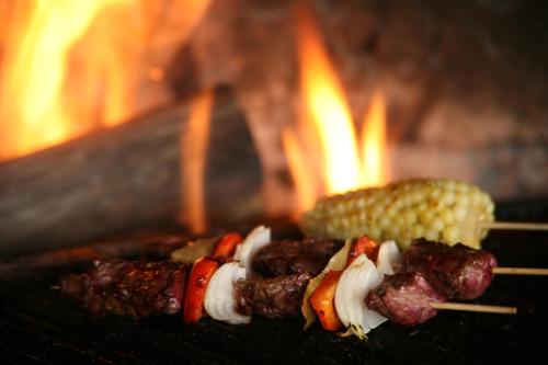 dos brochetas de carne y maíz en una parrilla en Hotel Ráquira Silvestre Lodge, en Tinjacá