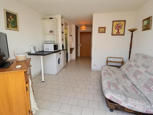 un petit salon avec un canapé et une cuisine dans l'établissement Studio en RDC avec Jardin Privatif et Piscine, à 50m de la Plage - Saint-Cyprien - FR-1-732-6, à Saint-Cyprien