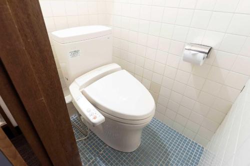 a bathroom with a white toilet in a stall at Ooedo Onsen Monogatari Premium Hotel New Shiobara in Nasushiobara