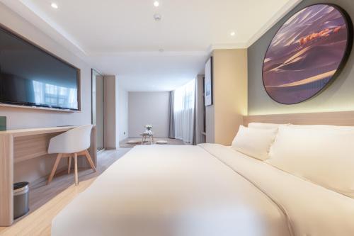 a hotel room with a large bed and a tv at Atour Light Hotel (Chengdu Hi-tech West Zone University of Electronic Technology) in Chengdu