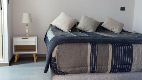 un letto con cuscini sopra in una camera da letto di Hermoso departamento de 1D, terraza y vista al mar ad Antofagasta