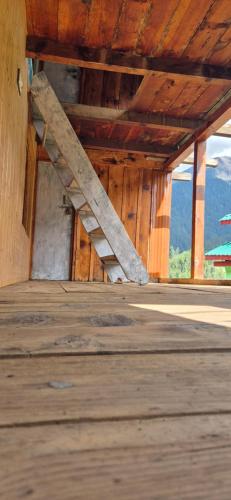 a staircase in a building with a wooden floor at Blabla House Himachal in Pulga