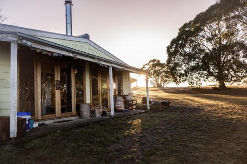 an old house sitting on the side of a field at Askara Lake House in Willunga