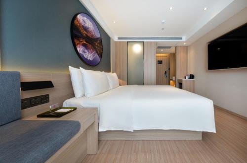 a bedroom with a large white bed and a tv at Atour Light Hotel (Chengdu Hi-tech West Zone University of Electronic Technology) in Chengdu