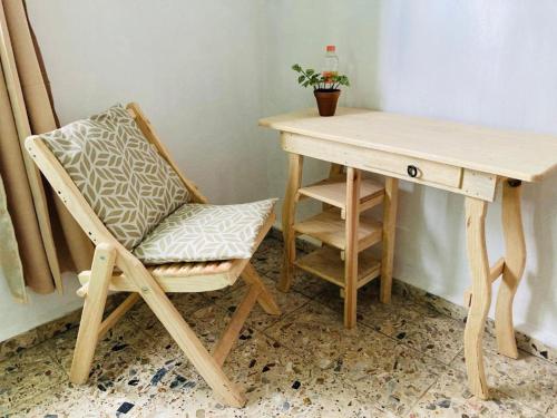 a desk with a chair next to a table with a plant at Alhambra Hotel - San Cristóbal de las Casas in San Cristóbal de Las Casas