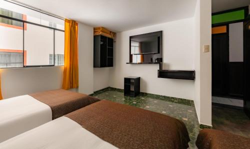 a hotel room with two beds and a window at Hotel Sierra Viva in Cajamarca