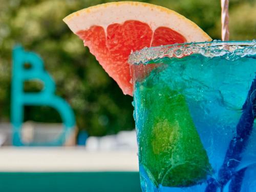 a drink with a slice of a watermelon and a lemon at Kataléa - Plage, Piscine, Espace détente in Grand-Bourg