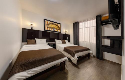 a hotel room with two beds and a window at Hotel Sierra Viva in Cajamarca