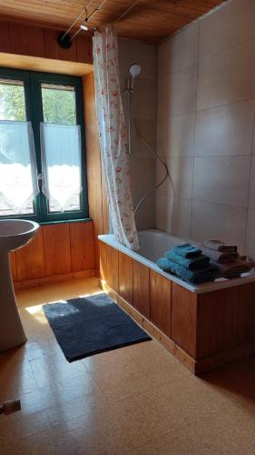 une salle de bain avec une baignoire et un lavabo dans l'établissement Les Gîtes Du Larderet, à Le Larderet
