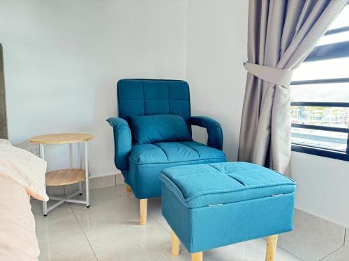 a blue chair and a stool in a bedroom at 31 RIMBUN KIARA KEPAYANG SEREMBAn in Seremban