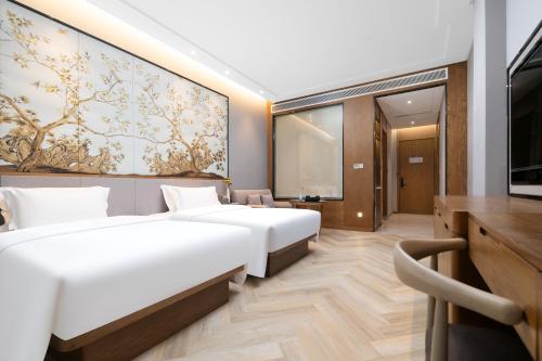 a hotel room with two beds and a tv at Ramada by Wyndham Wuhan Wangjiawan in Wuhan